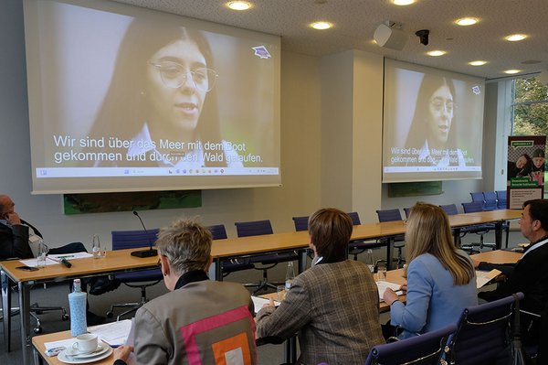 Blick in den Saal, das Publikum wird von Hinten gezeigt, auf der Leinwand läuft der Film "Ausbildung mittendrin: Die Azubis"