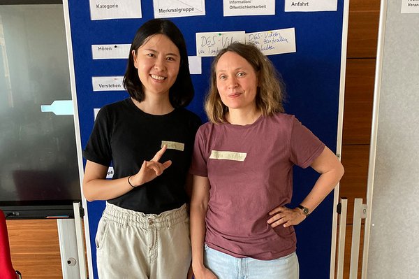 Ying Guo und Tina Sander vor Stellwand mit aufgepinnten Karten