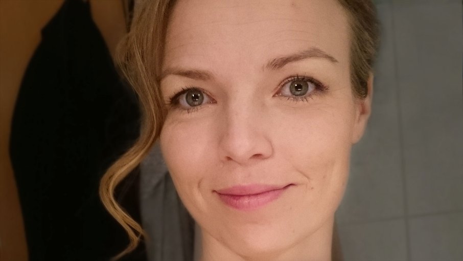 Sandra Nahaufnahme einer Frau frühen Alters, sie lächelt, eine Strähne ihres dunkelblonden Haares fällt ihr auf die Stirn